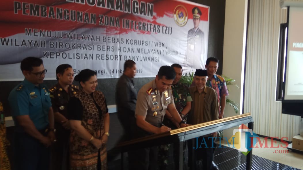 Kapolres Banyuwangi AKBP Taufik Herdiansyah Zeinardi menandatangani piagam pencanangan zona integritas untuk meraih WBBM.