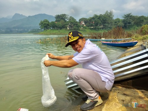 Wakil Gubernur Jatim Emil Dardak saat menebarkan benik ikan di Waduk Selorejo, Minggu (24/2/2019). (Foto: Irsya Richa/MalangTIMES)