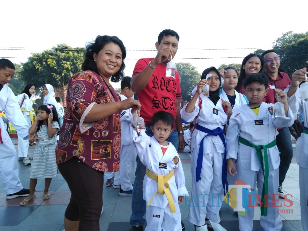 Warga dan anak-anak menerima ikan cupang yang dibagikan komunitas peternak ikan cupang.(Foto : Team BlitarTIMES)