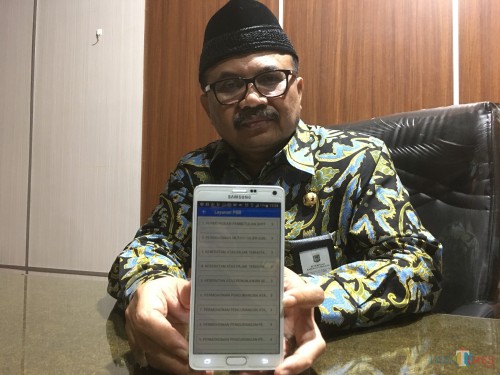 Kepala Badan Pendapatan Daerah (Bapenda) Kabupaten Malang Purnadi, saat menunjukkan aplikasi SimplePBB berbasis online yang bisa diunduh melalui play store (Foto : Ashaq Lupito / MalangTIMES)