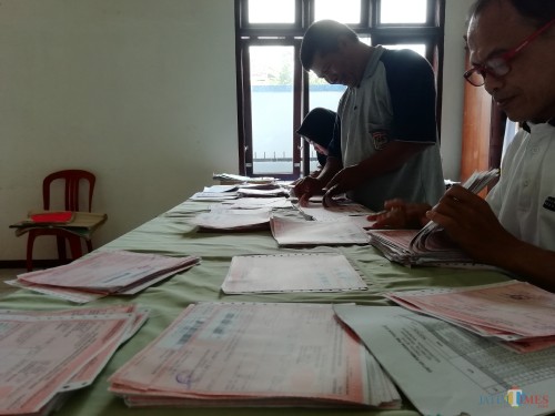 Perangkat Desa Kromengan, Kromengan, saat mengelompokkan SPPT PBB P2 di kantor desa, Jumat (01/03) (foto: Nana/ MalangTIMES)