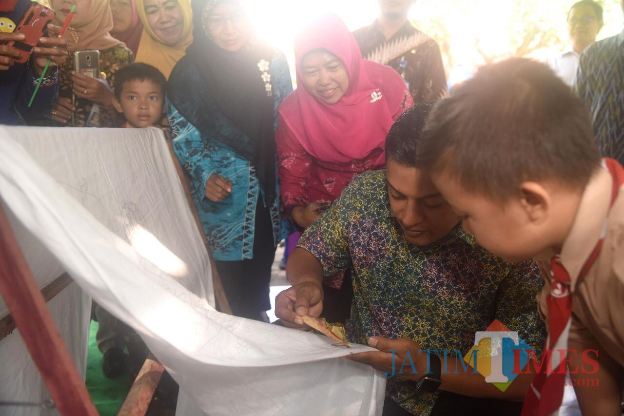 Wali Kota Kediri Abdullah Abu Bakar membatik di sehelai kain di SD Tamanan Kota Kediri. (Eko Arif S / JatimTIMES)