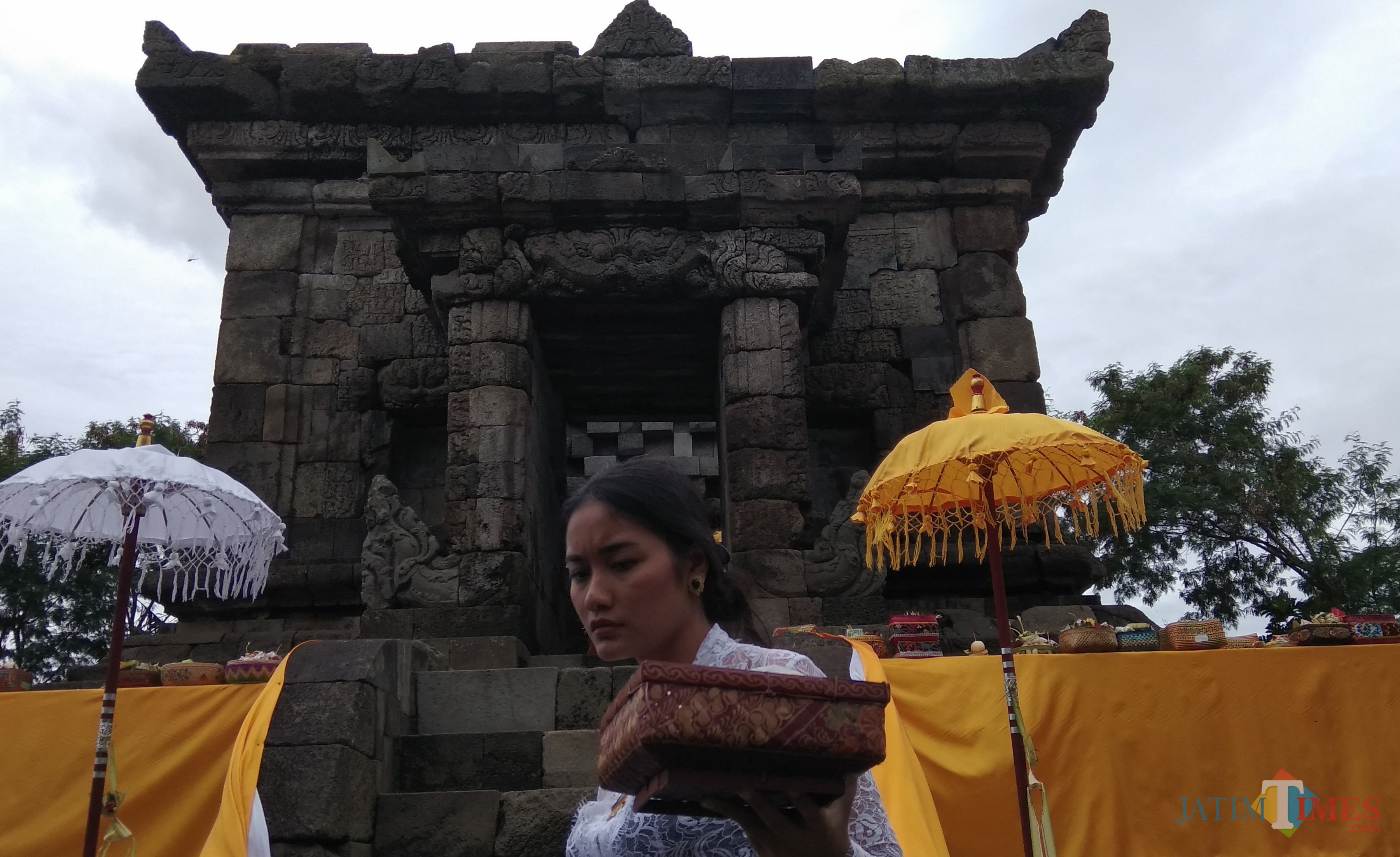 Salah satu umat Hindu asal Kota Malang tengah membawa sesaji untuk upacara Ngembak Geni di Candi Badut. (Foto: Nurlayla Ratri/MalangTIMES)