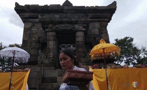 Salah satu umat Hindu asal Kota Malang tengah membawa sesaji untuk upacara Ngembak Geni di Candi Badut. (Foto: Nurlayla Ratri/MalangTIMES)