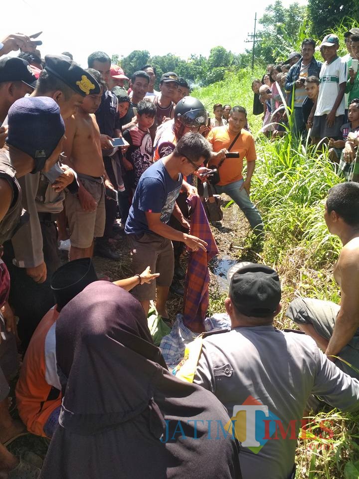 Warga dan petugas kepolisian saat hendak mengevakuasi mayat korban (foto : istimewa / Jatim TIMES)