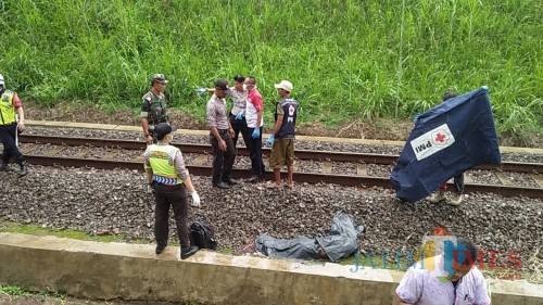 Petugas saat mengevakuasi jenazah korban yang tewas akibat tersambar kereta. (Foto : Dokumen MalangTIMES)