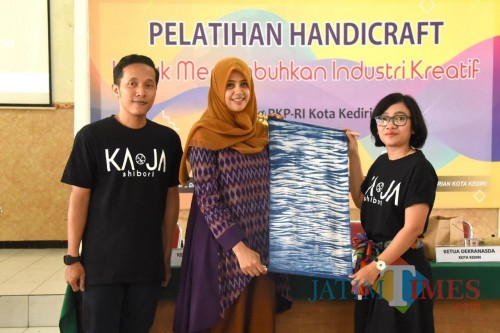 Ketua Dewan Kerajinan Nasional Daerah Fery Silviana Abu Bakar (tengah) saat menunjukkan kerajinan Handicraft. (Eko Arif S /JatimTIMES)