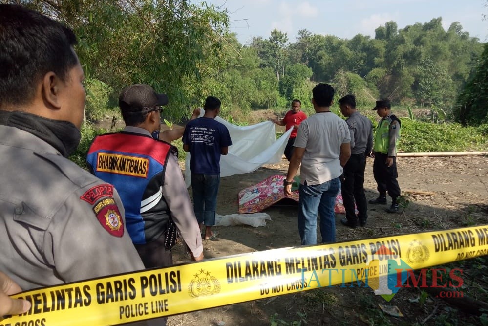 Petugas kepolisian ketika melakukan evakuasi korban. (Foto: B. Setioko/JatimTIMES)