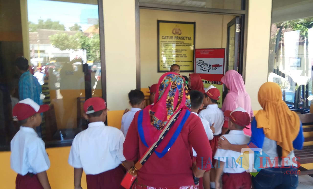 Wali murid dan siswa SD yang menjadi korban potong rambut tak beraturan saat melapor di Polsek Rogojampi.