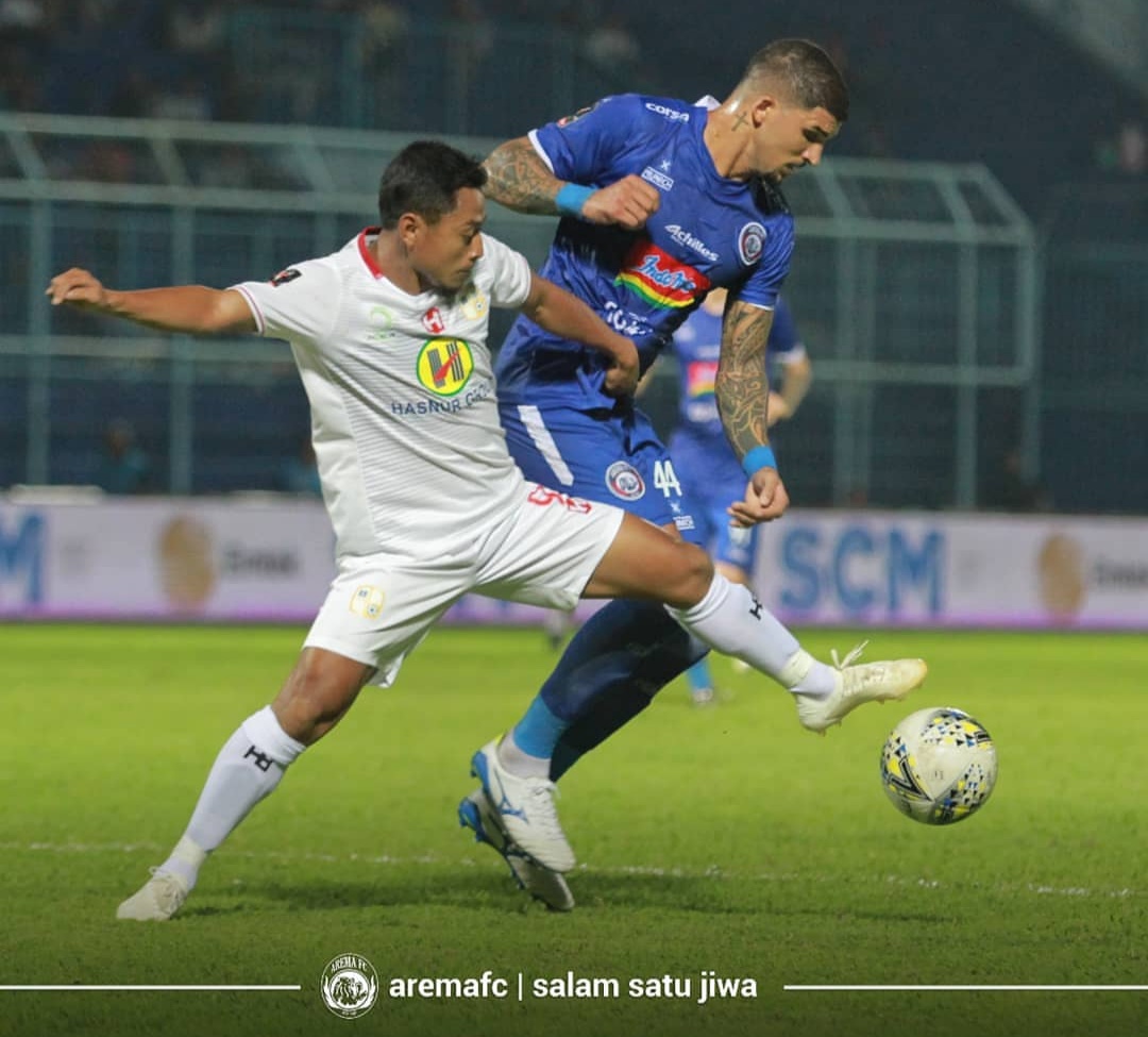 Arthur Cunha (baju biru) ketika berduel dengan pemain Barito Putera Samsul Arif (foto: official Arema FC)