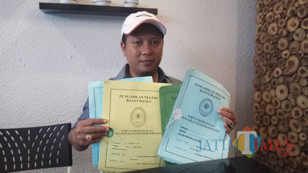 Pengacara Dewi Anjarwati, Dudy Sucahyo, menunjukkan berkas putusan Pengadilan pertama hingga kasasi