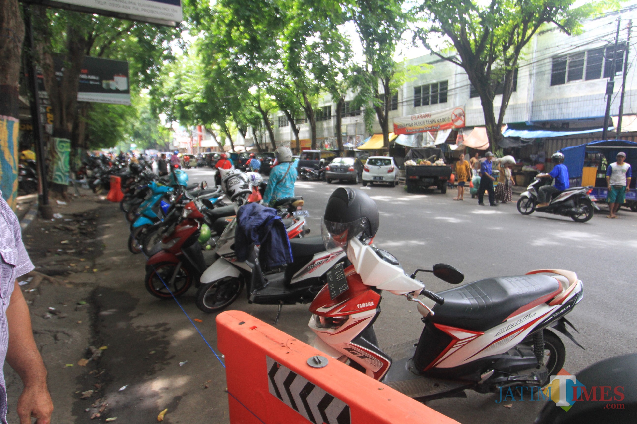 Parkir kendaraan roda 2 dan empat di depan pasar baru, yang menyebabkan kemacetan (Agus Salam/Jatim TIMES)