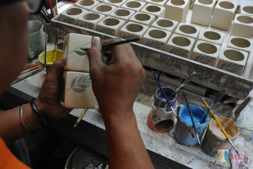 Proses pelukisan tungku aroma terapi di kampung wisata keramik Dinoyo