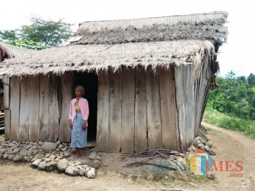 Nenek Suri alias Ibu Tolak berfose di depan gubuk reotnya (Foto: Heru Hartanto/ SitubondoTIMES)