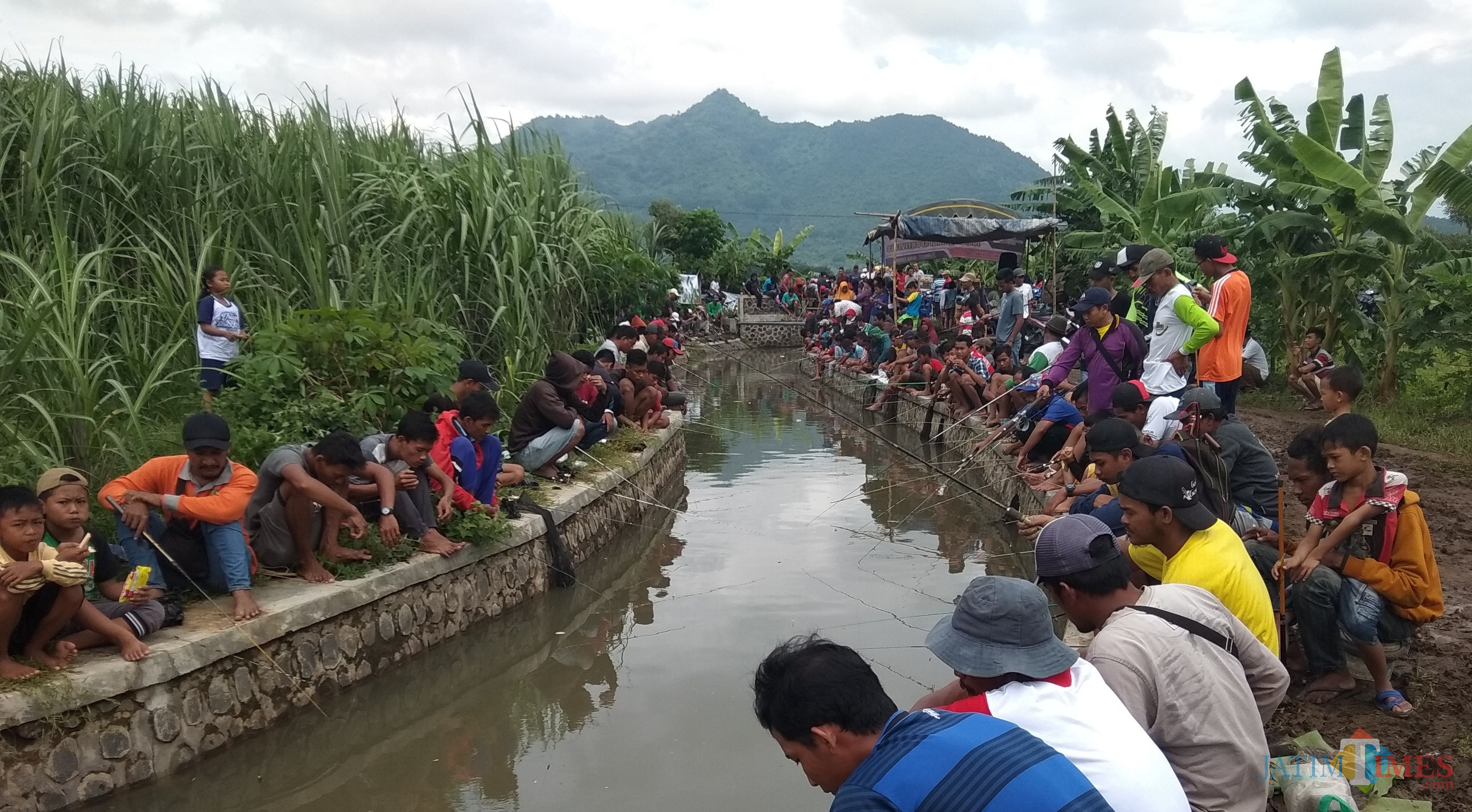 Para peserta memancing saat asik mengikuti lomba mancing ikan lele. (eko Arif s /JatimTimes)