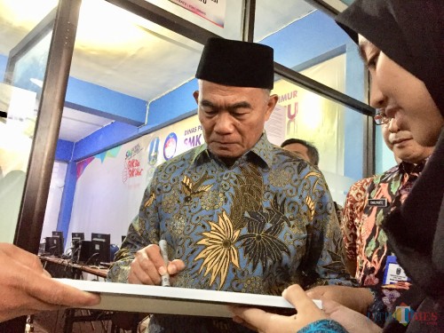 Mendikbud Muhadjir Effendy saat memberikan tanda tangan di SMKN 1 Batu, Selasa (26/3/2019). (Foto: Irsya Richa/MalangTIMES)