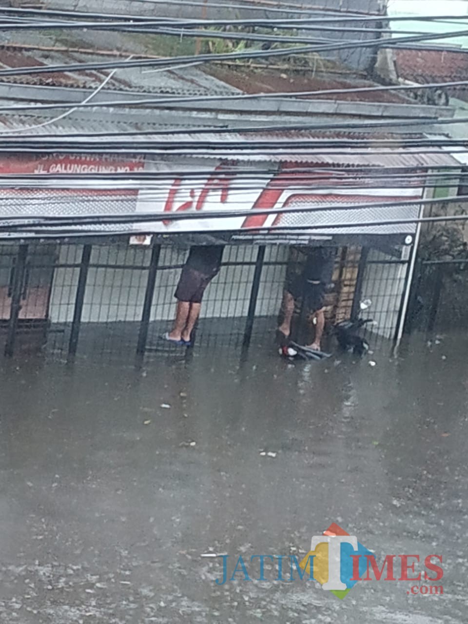 Warga memilih memanjat pagar untuk menghindari banjir yang terjadi di Kota Malang. (Foto: Dokumen MalangTIMES)