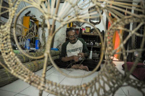 Samsul Subakri atau Mbah Kardjo saat membuat Wayang Suket di kediamannya yang terletak di Jl bantaran sungai Brantas dibawah jembatan Soekarno Hatta Kota Malang