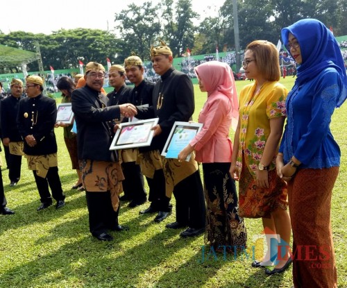 Kepala Dinas Perdagangan Kota Malang Wahyu Setianto saat menerima Piagam KIPP 2019 oleh Ketua DPRD Kota Malang Bambang Heri. (Foto: Nurlayla Ratri/MalangTIMES)