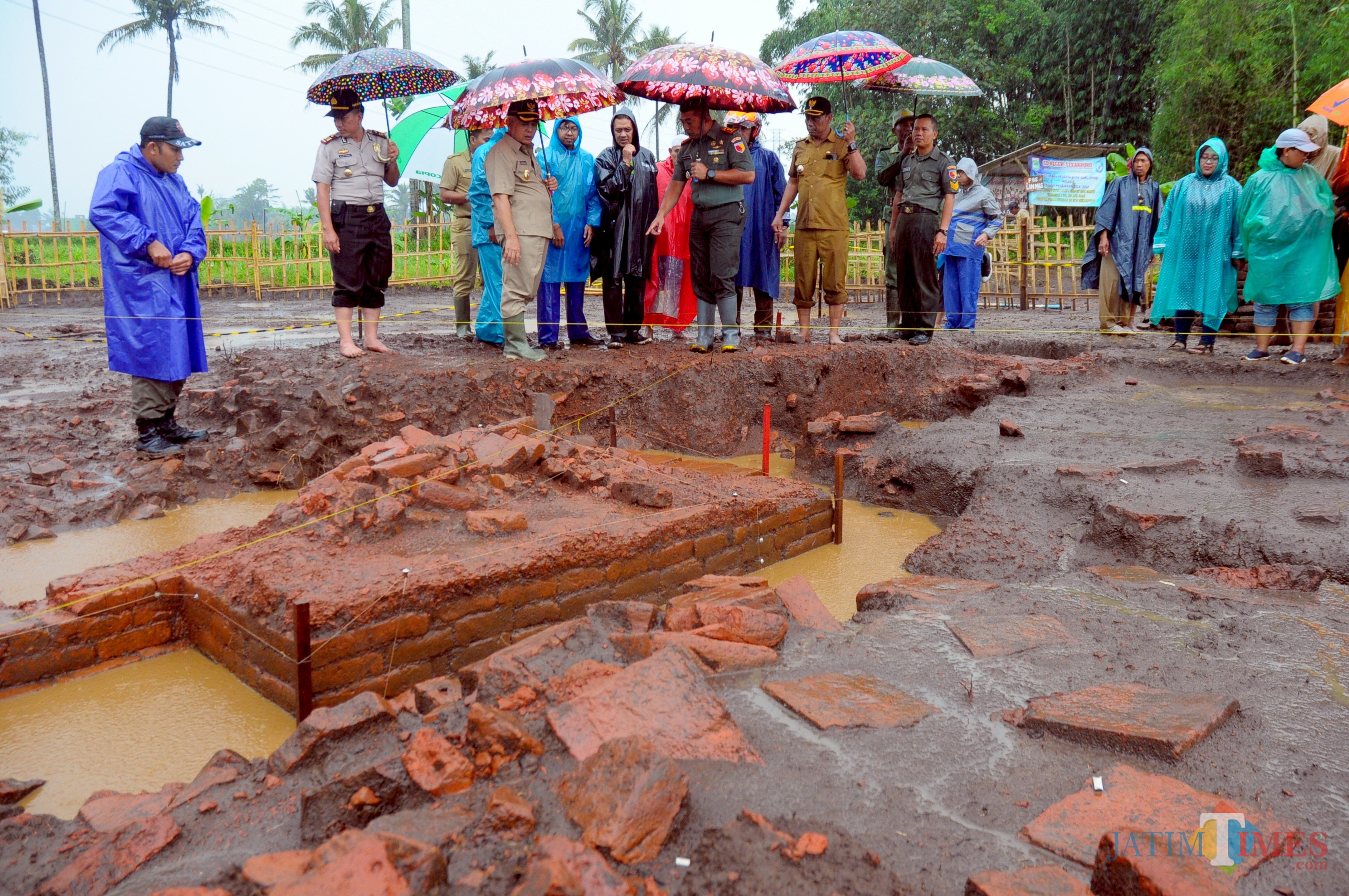Plt Bupati Malang didampingi oleh Muspika saat meninjau situs Sekaran ditengah hujan (Luqmanul Hakim/Malang Times)