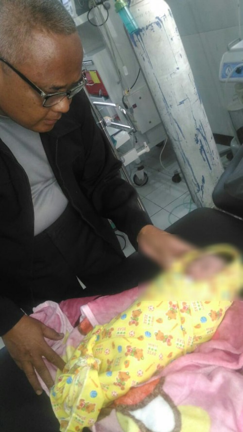 Kapolsek Songgon AKP Bakin melihat bayi yang ditemukan warga dini hari tadi.