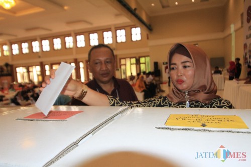 Salah satu pemilih saat memasukkan kertas suara yang sudah dicoblos (Agus Salam/Jatim TIMES)