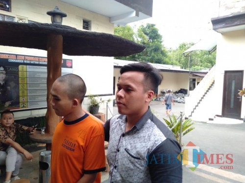 Ahmad Wahyu Dian Permadani alias Bocil (baju orange) tersangka kasus asusila terhadap anak di bawah umur, saat digelandang menuju ruang penyidikan UPPA Polres Malang (Foto : Ashaq Lupito / MalangTIMES)