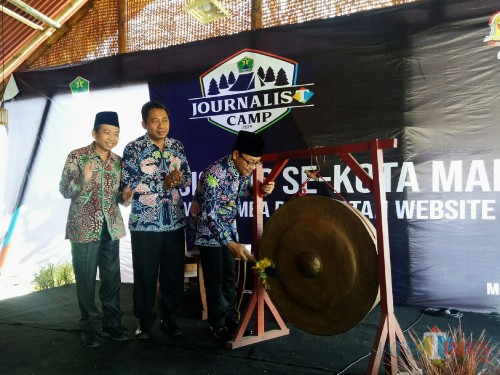 Wali Kota Malang Sutiaji (memukul gong) bersama Dirut JatimTIMES Ghufron Marzuqi dalam pembukaan Journalist Camp 2019. (paling kiri). (Foto: Imarotul Izzah/MalangTIMES)