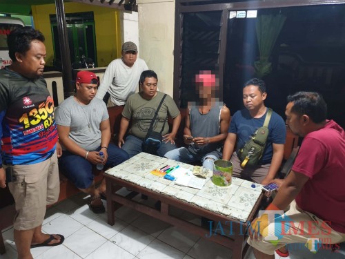 Teguh Supriadi (bawa uang) tersangka beserta barang bukti saat diamankan petugas kepolisian, Kecamatan Kalipare (Foto : Humas Polres Malang for MalangTIMES)
