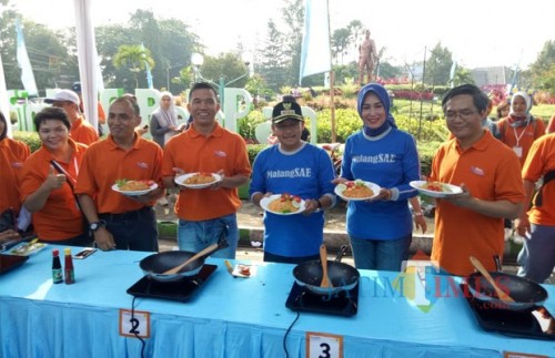 Wali Kota Malang Sutiaji beserta istri, Widayati Sutiaji (tengah kenalan baju warna biru) saat melakukan demo masak nasi goreng untuk mengkampanyekan hemat energi menggunakan kompor induksi (Humas Pemkot Malang for MalangTIMES).