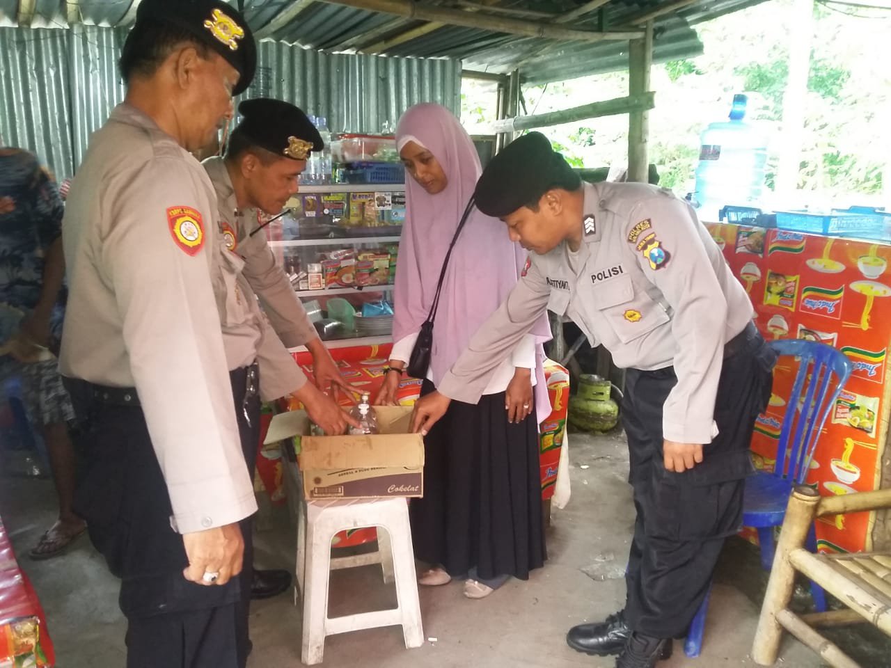 Petugas kepolisian saat melakukan razia miras disebuah toko (Humas Mahkota).