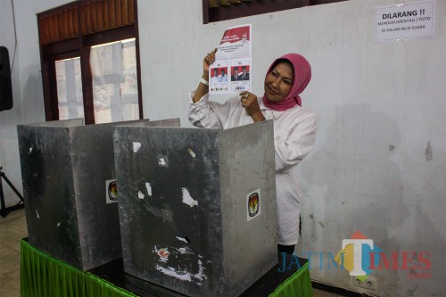 Wali Kota Batu Dewanti Rumpoko menunjukkan surat suara sebelum mencoblos dari balik bilik suara (Luqmanul Hakim/Malang Times)