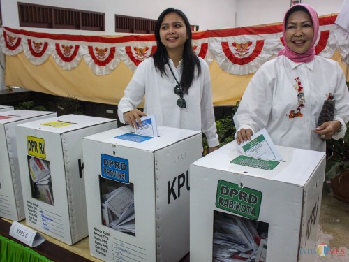 Ganis Rumpoko (kiri) dan Wali Kota Batu Dewanti Rumpoko (kanan) memasukkan surat suara di TPS di Kota Batu (Luqmanul Hakim/Malang Times)