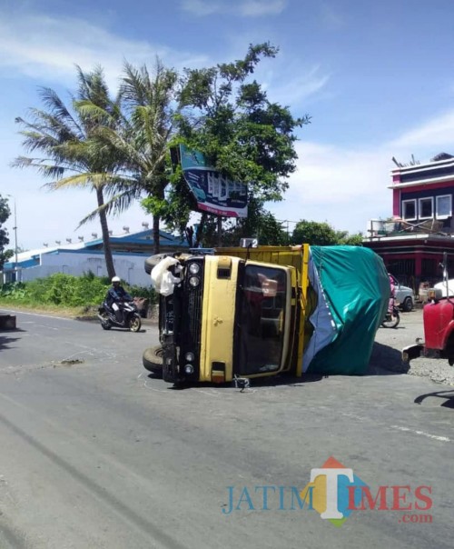 Truk yang terguling inilah yang melindas bagian tubuh korban (Agus Salam/Jatim TIMES)
