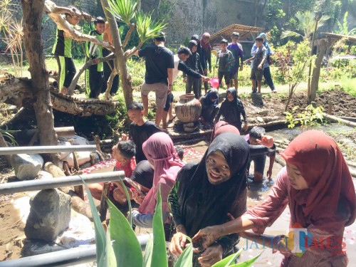 Siswa saat sedang membilas dengan air kembang di di grojogan Sendang Santren Kawasan Pesantren Rakyat, jalan Lahor, Desa Pesanggrahan, Kecamatan Batu, Sabtu (27/4/2019). (Foto: Irsya Richa/MalangTIMES)