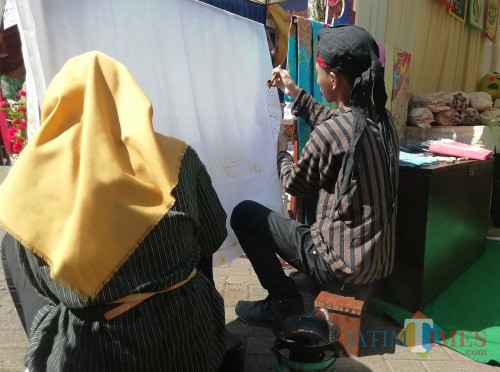 Dua pelajar kelas 9 SMP Islam Kalipare saat mempraktekkan membatik di depan standnya (Nana)