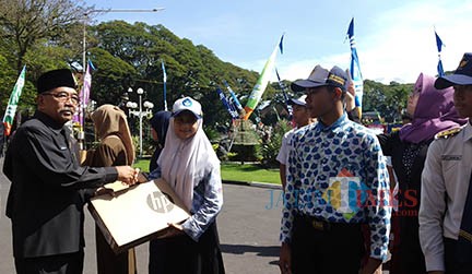 Nadya Salsabila Azzahra, perwakilan SMPN 20 Kota Malang, saat menerima hadiah laptop dari mendikbud dalam lomba website Journalist Camp 2019 pada Hardiknas Kota Malang beberapa hari lalu di Balai Kota Malang. (Pipit Anggraeni/MalangTIMES)