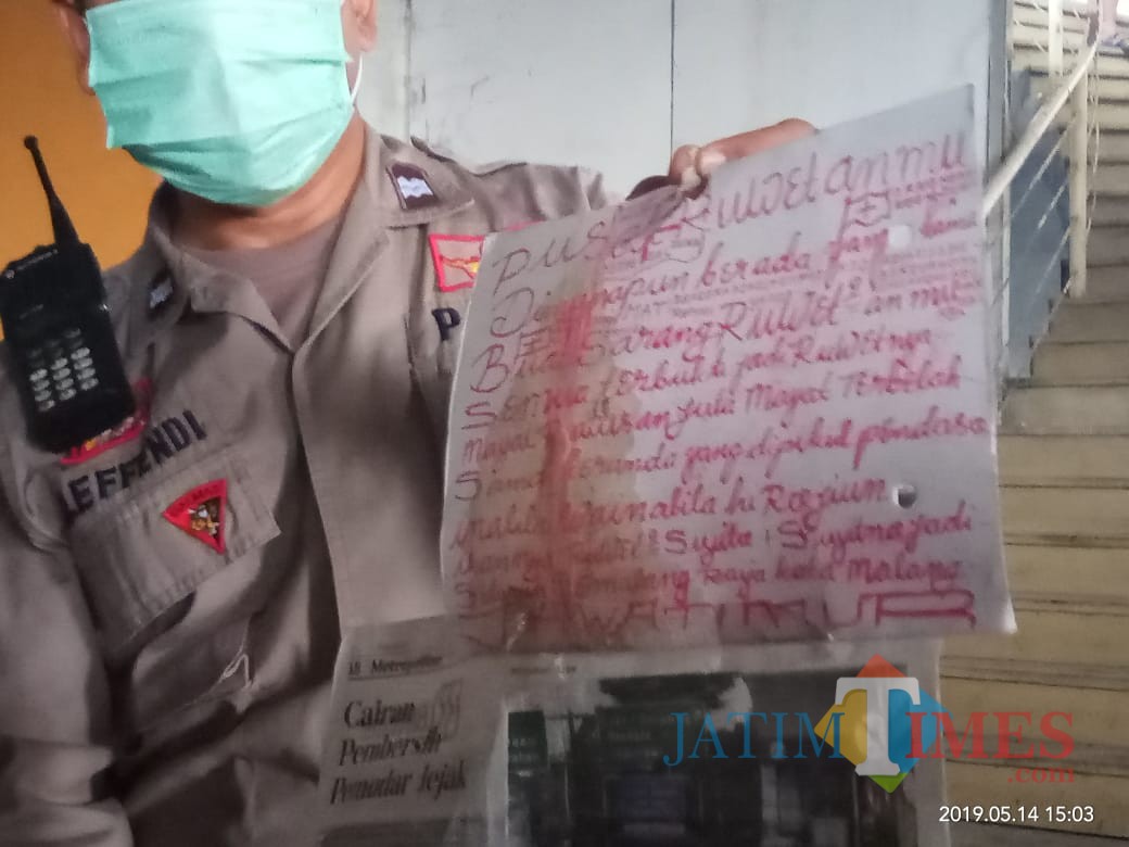 Polisi saat menunjukkan tulisan tangan yang diduga ditulis oleh pelaku mutilasi perempuan di Malang. (Foto: Dokumen MalangTIMES)