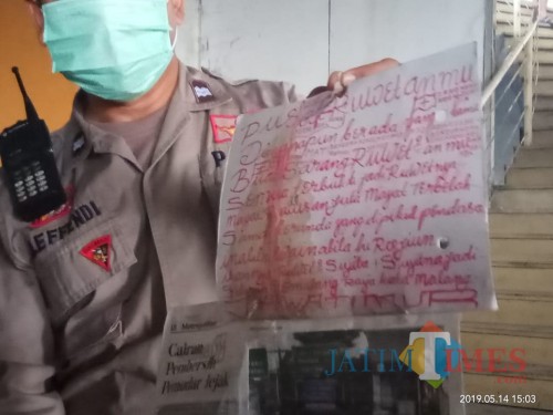 Polisi saat menunjukkan tulisan tangan yang diduga ditulis oleh pelaku mutilasi perempuan di Malang. (Foto: Dokumen MalangTIMES)