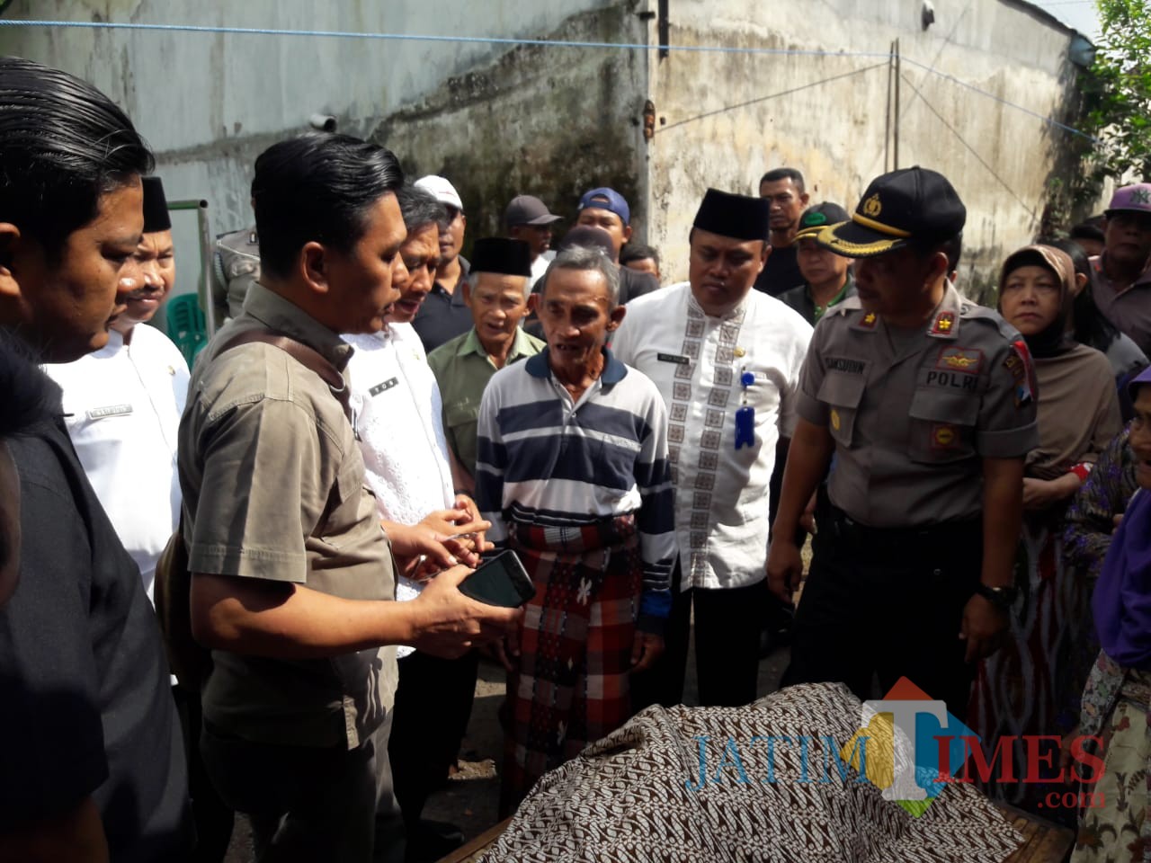 Petugas Polsek Genteng bersama warga membawa jenazah korban ke rumah kerabatnya