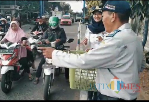 Petugas UPT Dishub Dampit saat membagikan takjil kepada masyarakat (Nana)