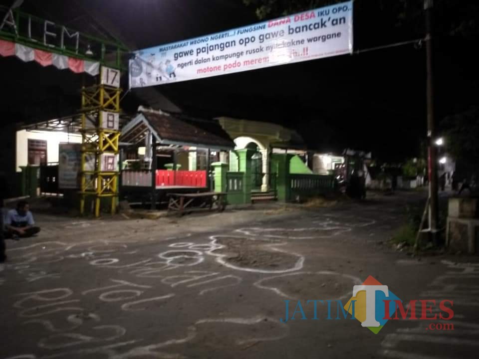 Warga mencorat coret dan memasang spanduk di jalan Desa Tlogo yang rusak
