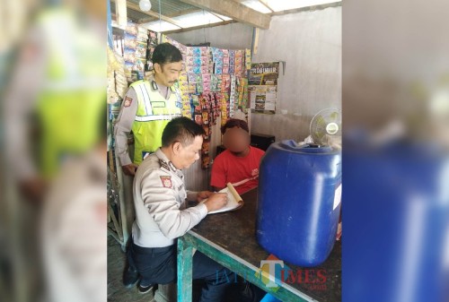 Riadi (baju merah), penjual miras, saat ditindak oleh petugas kepolisian di Kecamatan Pagelaran. (Foto : Humas Polres Malang for MalangTIMES)
