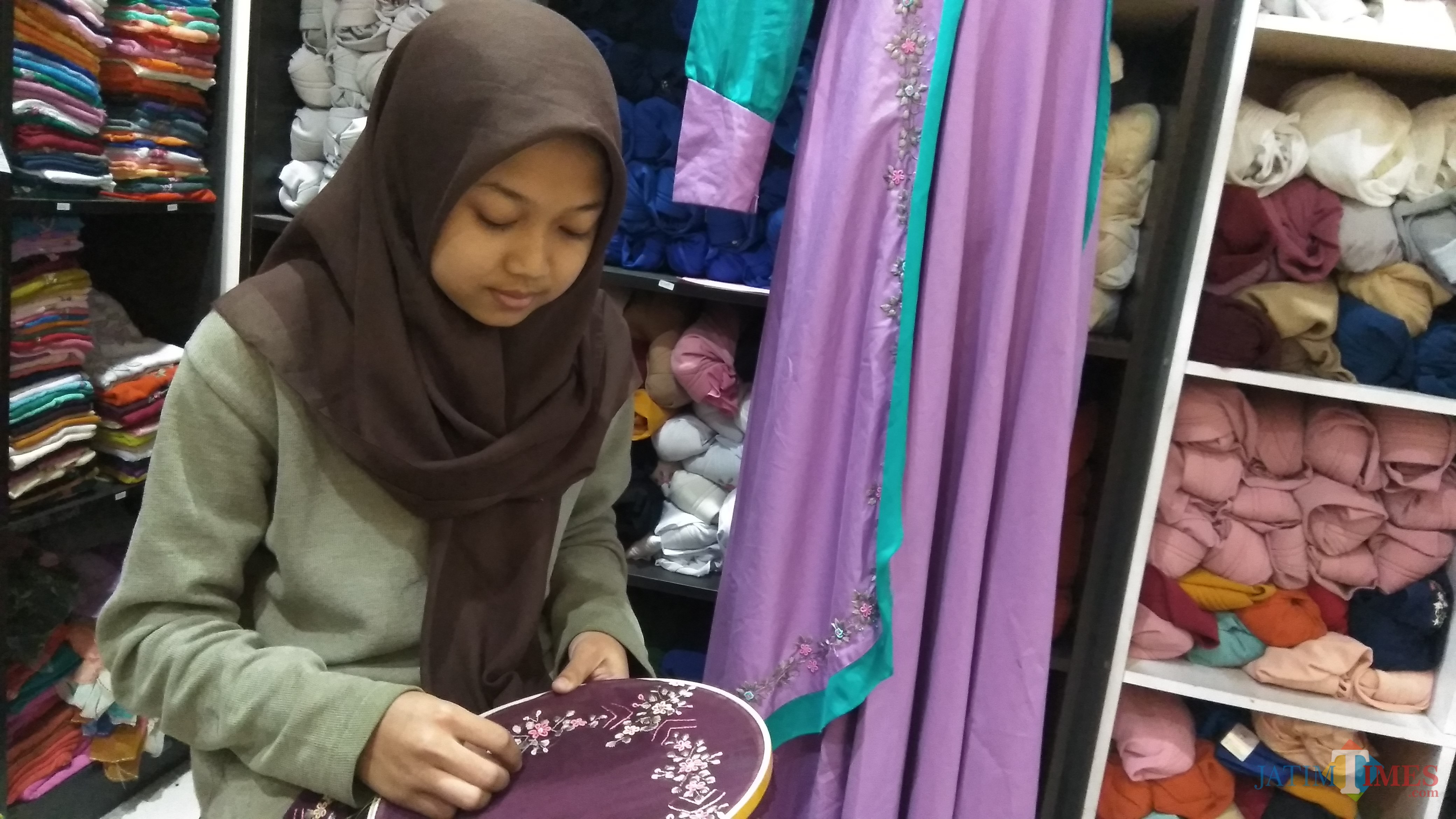 Perajin tengah menyulam hiasan di kerudung di rumah fashion Almira Handmade, Kota Malang. (Foto: Nurlayla Ratri/MalangTIMES)