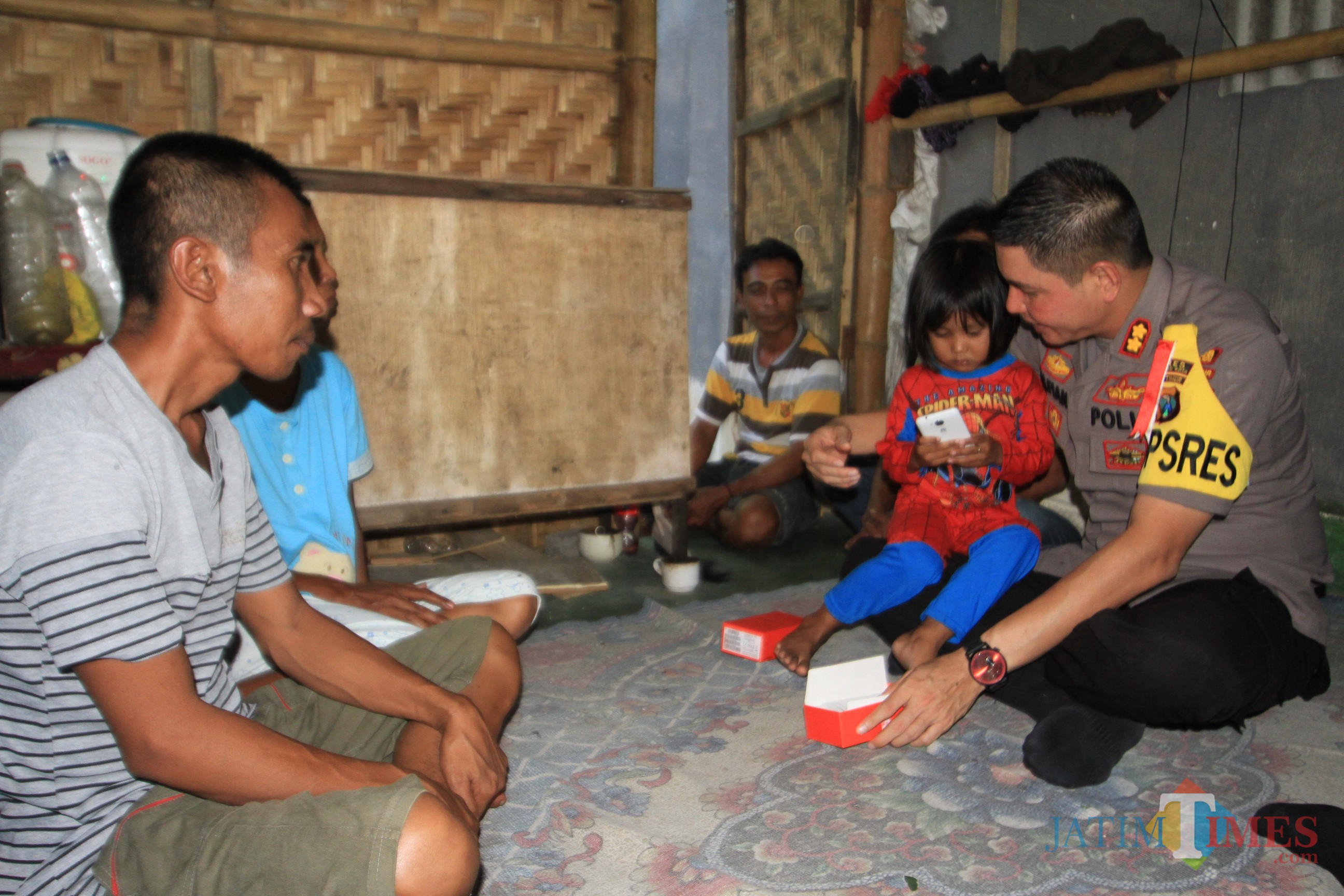 Kapolres Probolinggo Kota memberikan Hp ke putri bungsu pasutri Ruman dengan Supriya (Agus Salam/Jatim TIMES)