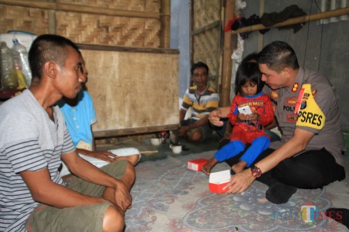 Kapolres Probolinggo Kota memberikan Hp ke putri bungsu pasutri Ruman dengan Supriya (Agus Salam/Jatim TIMES)