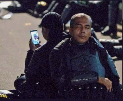Foto dua aparat kepolisian di tengah demo 22 Mei yang viral di medsos.(Ist)