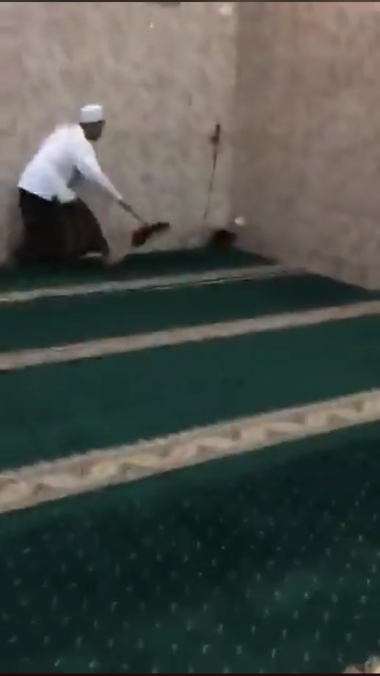 Salah satu jamaah saat mencoba mengusir tikus dari masjid. (Foto: istimewa)