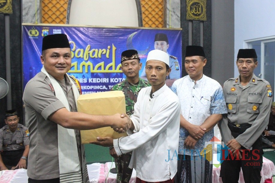 Waka Polresta Kediri Kompol Iwan Sebastian memberikan bantuan kepada anak kurang mampu. Foto: (B. Setioko/JatimTIMES)