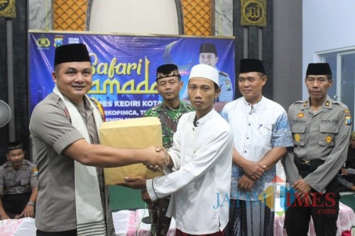Waka Polresta Kediri Kompol Iwan Sebastian memberikan bantuan kepada anak kurang mampu. Foto: (B. Setioko/JatimTIMES)